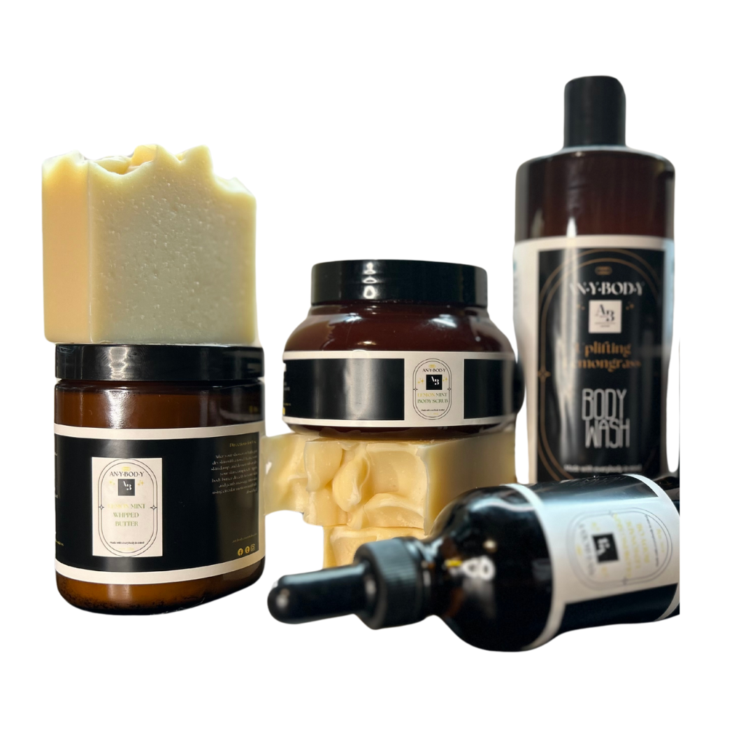 A collection of skincare products including a jar of body butter, a bottle of body wash or bar of soap, and body oil, and body scub